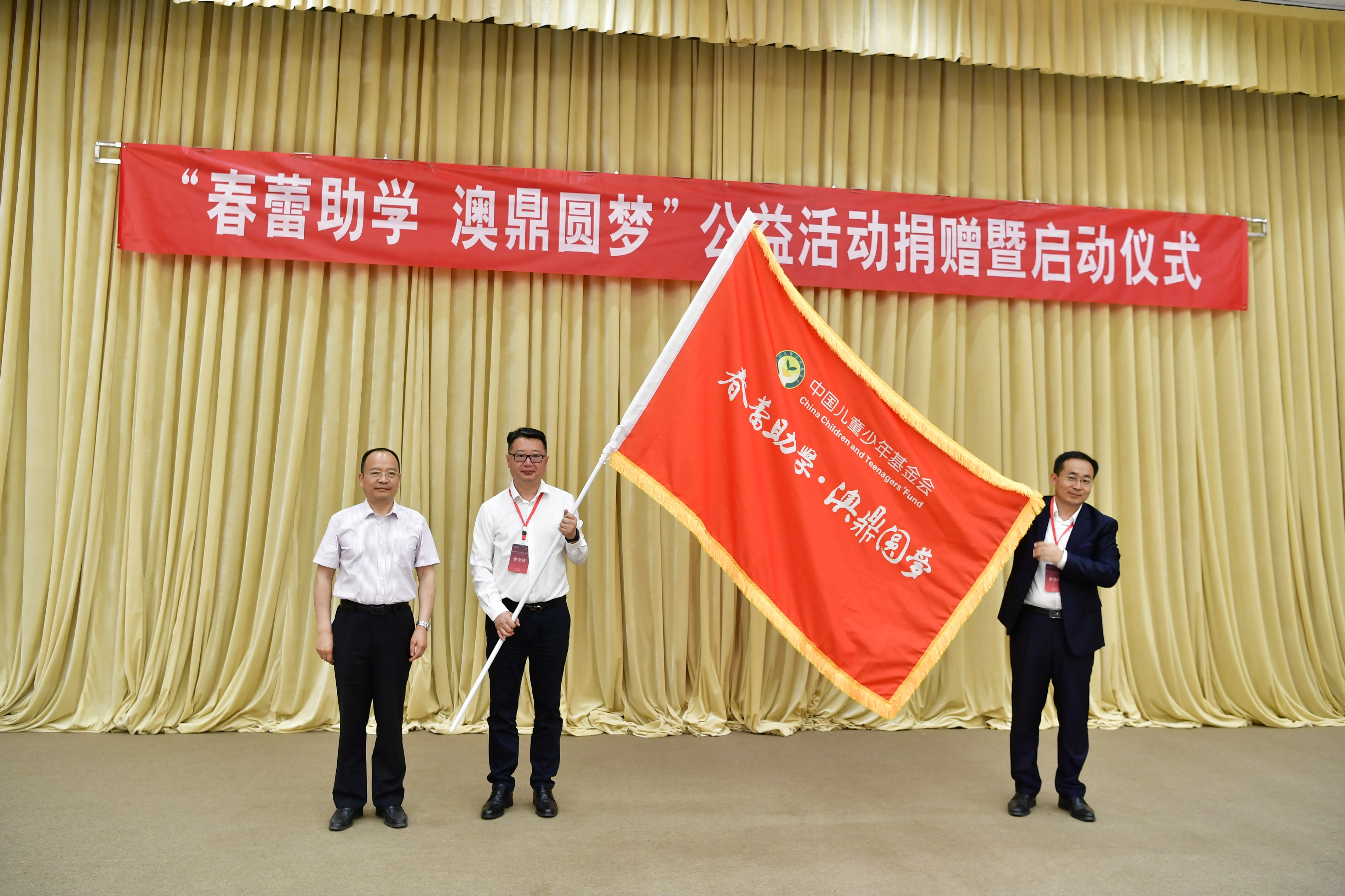 6.中国儿童少年基金会副理事长、秘书长朱锡生将印制“春蕾助学 澳鼎圆梦”的红色旗帜授给青岛澳鼎生物科技有限公司，象征2021年“春蕾助学 澳鼎圆梦”公益活动正式启动.JPG